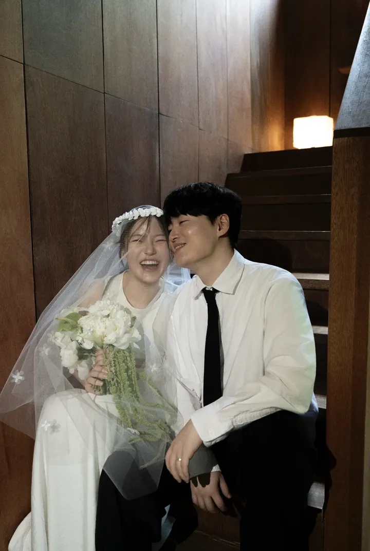 베일을 쓰고 계단에 앉아 함께 웃는 두 사람